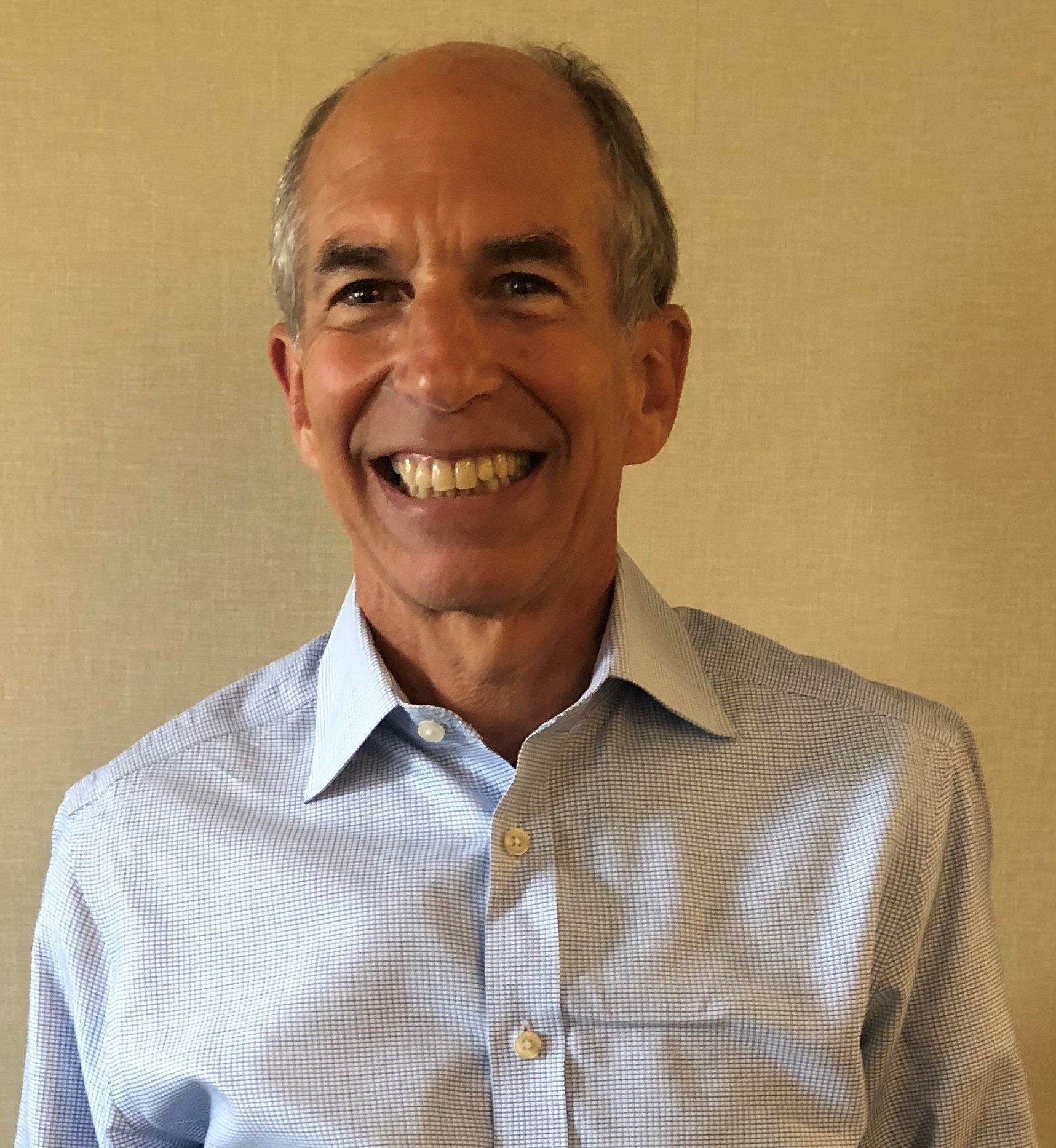 Man wearing light colored button up shirt smiling